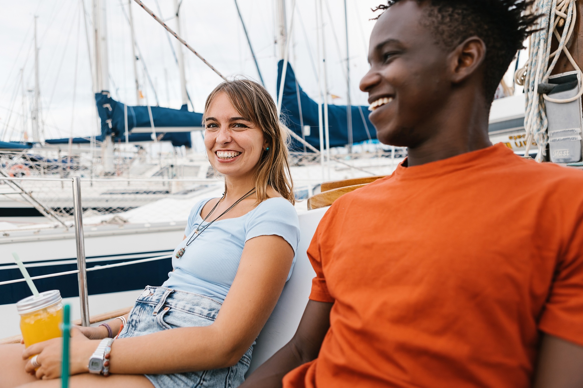 Happy multiracial couple having fun outdoors on a boat.